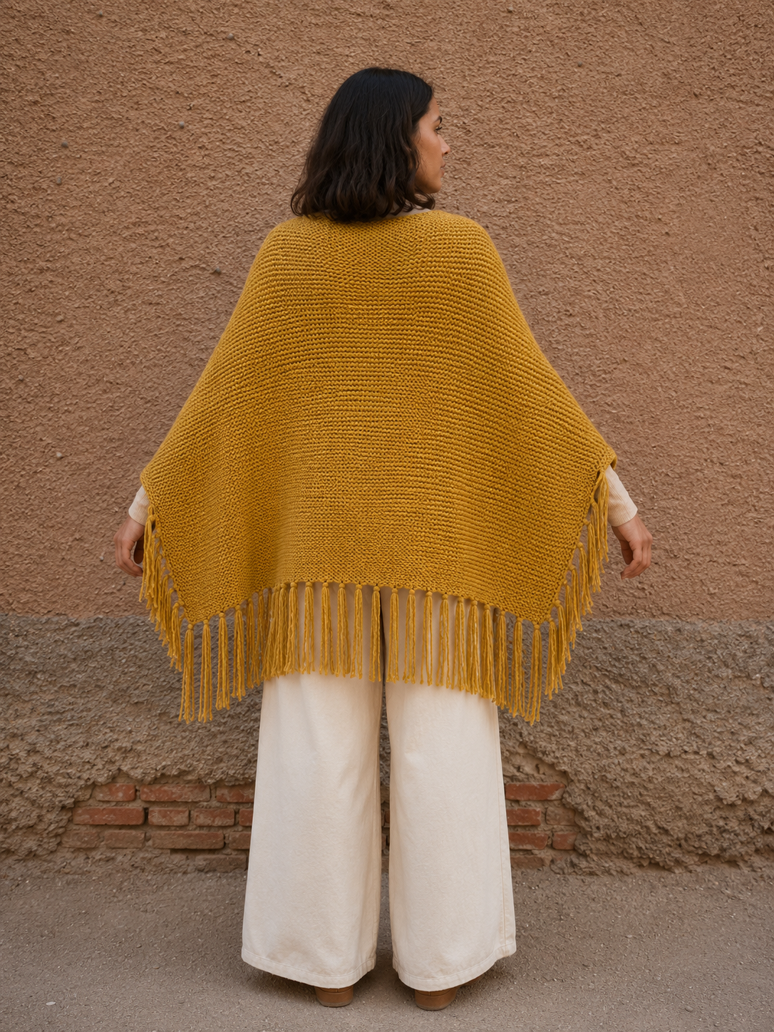 Poncho tejido color mostaza con flecos
